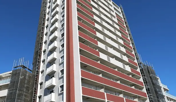 複数階建ての茶色い外観のマンション。バルコニーが特徴的で、木々が並ぶ落ち着いた住宅街に立地。
                                                                